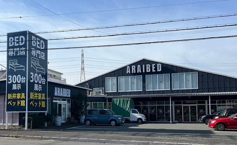 新井家具ベッド館 大阪枚方本店の外観と店舗前駐車場
